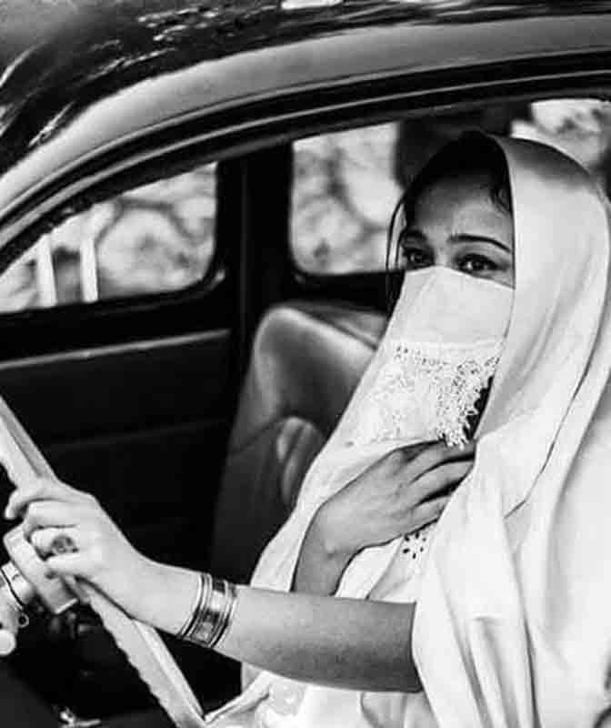 Portrait d'une algérienne voilée au volant d'une voiture